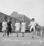 Des ouvrières des munitions font une promenade avec des amies à l'heure du déjeuner à l'usine Dominion Arsenals Ltd 24 août 1942