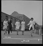 Women munitions workers enjoy a lunch-time walk with friends at the Dominion Arsenals Ltd. plant 24 Aug. 1942
