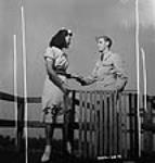 Une ouvrière des munitions à l'usine de la Dominion Arsenals Ltd. prend la main de son ami de coeur pendant une sortie 24 Aug. 1942