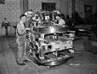 Aux Ateliers d'Ingénierie Dominion, des ouvriers travaillent sur le palier en laiton d'un canon « Pom-Pom » antiaérien multiple (4) de 2 livres 1942
