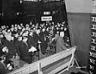 Au chantier naval Montreal Vickers, la foule se rassemble pour assister au baptême au champagne du bateau U.S.S. Danville lors de sa cérémonie de lancement 14 nov. 1942
