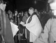 Un prêtre bénit le 100e lancement d'un navire de charge lors de la cérémonie de lancement Dec. 1942