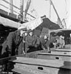 Women workers bolt steel girders in place over the hold of a new ship in the Pictou shipyard janv. 1943