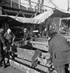 Au chantier naval de Pictou, des ouvrières boulonnent des poutres en acier au-dessus de la cale d'un nouveau navire janv. 1943