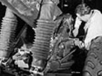 Un ouvrier effectue un dernier ajustement sur le carter des engrenages de pointage en hauteur d'un affût de canon de 5,5 pouces à l'usine National Railways Munitions Ltd 9 févr. 1943