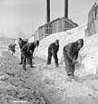 Des ouvriers sur le terrain retirent la glace des rails d'une voie ferrée lors du projet d'aménagement hydroélectrique de Shipshaw Jan. 1943