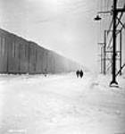 À l'usine Alcan Aluminium Limitée d'Arvida, des ouvriers marchent dans la rue Hall, un chemin d'un mille et demi de longueur janv. 1943