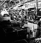 Workmen assemble army vehicles at the General Motors Plant in Oshawa ca. 1942