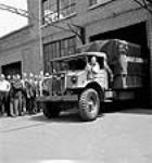 Un ouvrier conduit un véhicule militaire de l'usine General Motors d'Oshawa portant l'inscription « 500 000e » June 1943