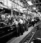 Workmen on an assembly line at the General Motors plant in Oshawa assemble a motor juin 1943