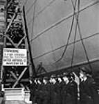 Femmes officiers du Service féminin de la Marine royale du Canada (WRCNS) alignées sur l'allée d'un podium de baptême au cours de la cérémonie du lancement du S.S. FORT ESPÉRANCE au chantier de la United Shipyards sept. 1943