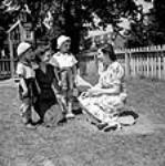 A Canadian mother, Mrs. Jack Wright says goodbye to her two sons Ralph Wright and David Wright whom she leaves at a day nursery while she works at a part-time job Sept. 1943