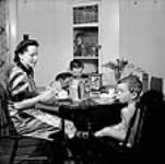 Mme Jack Wright et ses deux fils, Ralph et David, prennent leur petit déjeuner sept. 1943