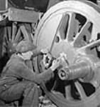 Un ouvrier peint l'étoile des Indes sur les roues d'une locomotive X/Dominion pour expédition en Inde nov. 1943