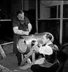 Les ouvriers Albert Kelley et Melville Reed enlèvent les bavures d'une tête de torpille avant de lui faire subir des essais à l'usine John Inglis Co May 1944