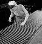 Female worker Jenny Johnston of Winnipeg, Manitoba, gauging bores of barrels of Lee Enfield rifles being produced for China by Small Arms Ltd Apr. 1944