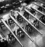 Workmen conduct a thorough inspection of naval guns using gauges in the Sorel Industries plant Summer 1943