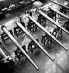 À l'usine Sorel Industries, des ouvriers effectuent une vérification minutieuse sur un canon naval au moyen d'instruments de mesure Summer 1943