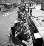 Workmen test the sights on twin Oerlikon guns, newly installed on aircraft carrier escort vessels at Burrard Dry Dock to make sure bullets clear the bulwarks and give a fifteen-foot clearance over the flight deck." mai 1944