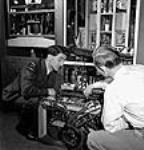 À l'usine RCA Victor, (à gauche) le sergent Peter Degenstein, de North Battleford (Sasketchewan), et Victor Isaac effectuent les derniers ajustements et essais sur des émetteurs à moyenne portée avant leur expédition juil. 1944