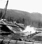 Logs rolling down a ramp into a lake from an inland logging camp near Gordon Pasha Lakes July 1944