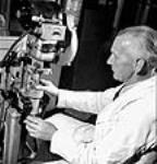 L'ouvrier Frank Millican ferme des bouteilles de pénicilline après que lemédicament ait été déshydraté aux laboratoires Connaught June 1944