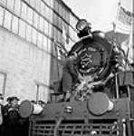 Official christens the first of 145 "X-Dominion" locomotives built in Canada for India under the Mutual Aid Board Agreement before its test run nov. 1943