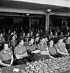 Des ouvrières dans un auditorium regardent un film de l'Office national du film du Canada présenté à l'usine Hughes Owen 17 oct. 1943