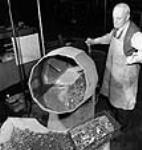 Un ouvrier supervise le lavage des pièces de métal pour la fabrication d'armes à l'usine de la John Inglis Co 10 avri1 1944