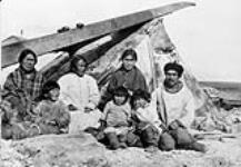 Inuit family at the Hudson Bay Co's Post, Southampton Island, N.W.T [The man has been identified as Kootoo and the woman in the shawl has been identified as Kanayuq] 1926.