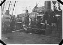 Inuk aboard C.G.S. Arctic. The Inuit man against the mast is Nuqallaq, who shot the fur trader Robert S. Janes 1922