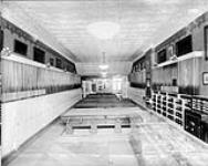 Interior of a showroom for billiards equipment, displaying cues, tables and other accessories ca 1920s