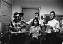 Canadian Broadcasting Corporation radio broadcasting studio, Iqaluit, Nunavut [Front row: Elijah Menarik (left) and Leah Idlout (right); back row, left to right: Abe Okpik, Peter Murdoch and Simonie Michael] 1961.