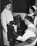 Doctor and nurse at the Ottawa Civic Hospital are examining the gastrointestinal tract of a patient by means of fluoroscopy c 1955