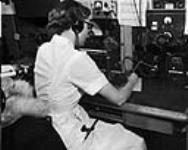 Outpost nurse is receiving medical information from a doctor via radio 1959