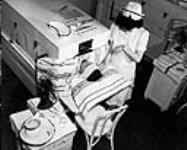 Nurse is treating a patient with fever therapy at an unidentified hospital in Ontario ca. 1950.