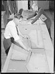 Workmen create garment templates for army service uniforms at the Great Western Garment Co 16 Apr. 1942