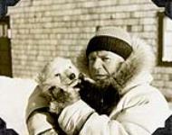 Dr. "Perce" Corbett, station doctor at Chesterfield Inlet, posing with an orphaned polar bear cub 1952