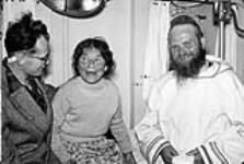 Portrait of an elderly female Inuit and two unidentified white males 195-?