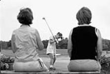 Erinn, 17 years old, practices her swing at the driving range; she and her father are avid golfers July, 2003