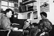 Woman and two children talking to an RCMP officer 1949 ou 1950.