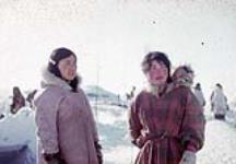 Two young Inuit women and an infant [Hannak (left) and Bessy Kimirut (right), who is carrying her baby in her amauti] 1953.
