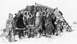 Group of Inuit outside of stone building n.d.