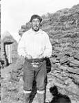 Inuk man in front of stone structure 1909