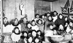 Inuit men, woman and children gathered for Christmas dinner and a dance, Herschel Island (Qikiqtaruk), Yukon 1909