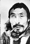 Close-up photograph of an Inuk man "Hulllalark" smoking a pipe n.d.