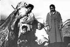 [Qatsuq Evic, with her mother, Aasivak, seated in Pangnirtung, Nunavut] Inuit women and children in front of tupiq at Fort Raid n.d.
