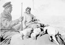 Two Inuit men in a boat with dead ducks ca. 1929-1934