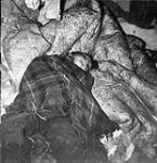 Inuk boy asleep on caribou skin blankets 1948