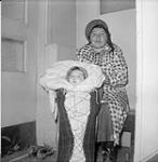 [Pukatawagan Indian Reserve, Manitoba - Woman poses with infant in a cradle board] n.d.